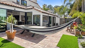 A modern house with a tiled roof, a hammock, and a patio with artificial grass and potted plants. - 2 minute walk to Del Mar Beach! (Del Mar)