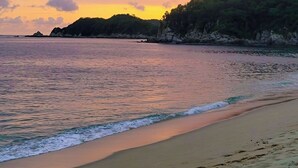 A beach with calm waters and a sunset. - Huatulco beauty in Chahue Bay. Large family condo with ocean and mountain views (Chahue)