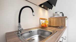 A modern kitchen with a stainless steel sink, a black faucet, a wooden countertop, and a built-in oven. - KATARINA One-Bedroom Apartment with Terrace 2 (Rovinj)