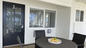 A room with a round table, two chairs, a door with a number, and a window.