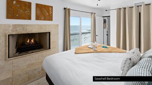 Camera con le conchiglie, dotata di camino, ventola a soffitto, letto vista oceano e balcone con tende.
