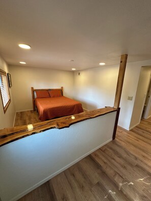 Ein Schlafzimmer mit einem Bett, einem Holz-Kopfteil und einer Holzablage.