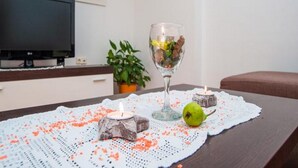 Ein Esstisch mit Kerze, einem Wasserglas und einer Frucht auf einer Tischdecke.