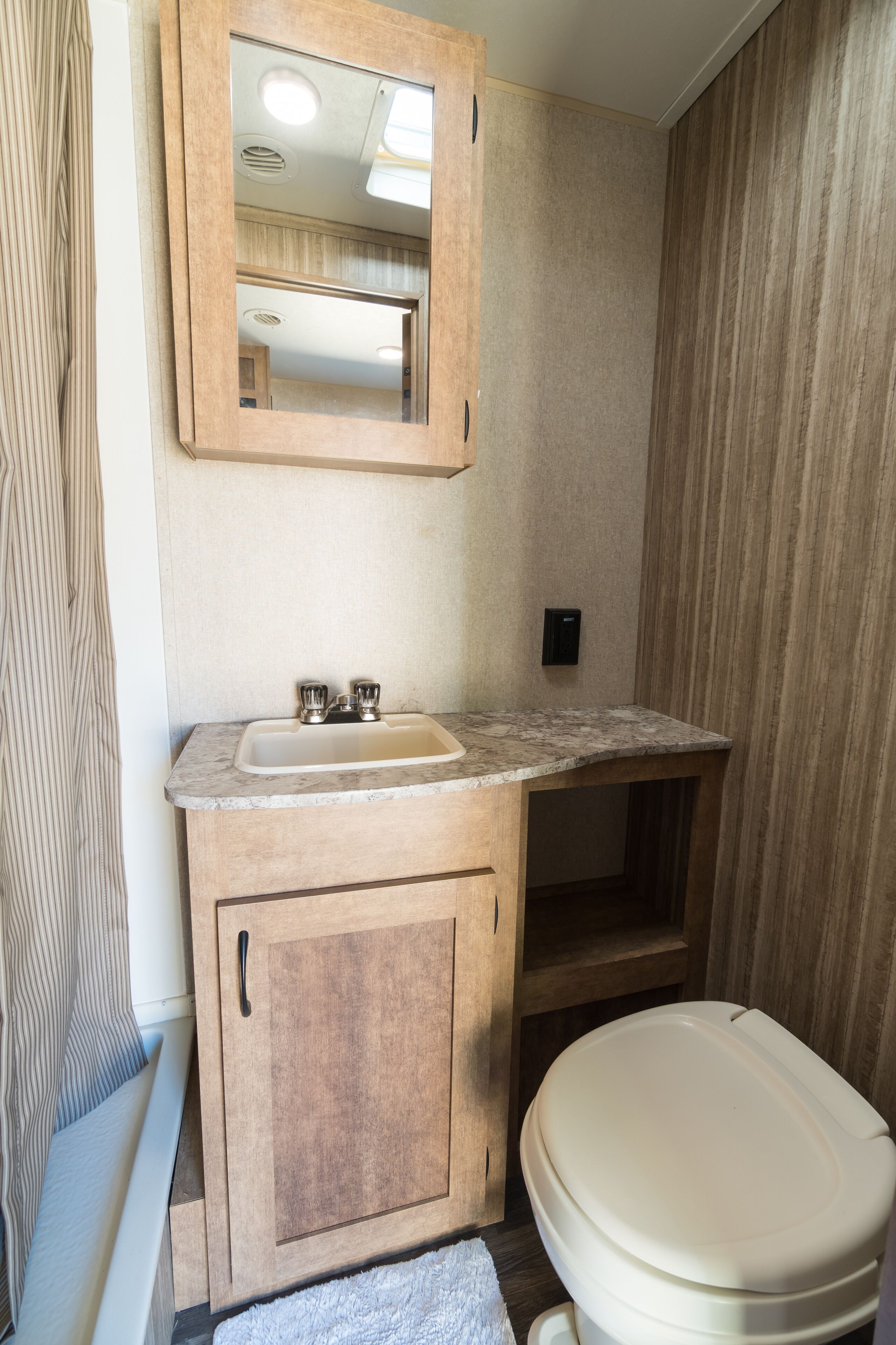 Een kleine badkamer met een houten wastafel, een wastafel en een toilet.