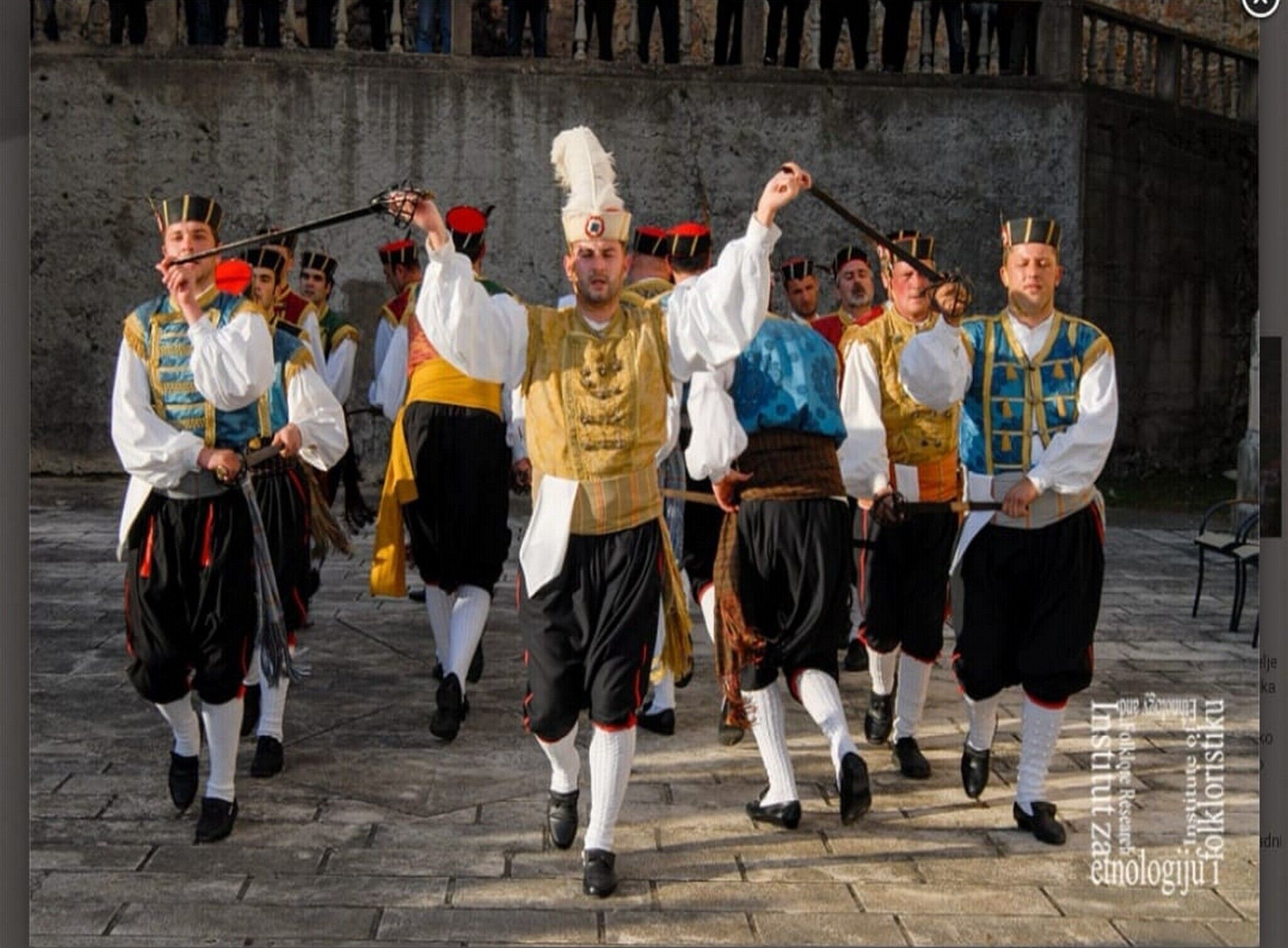 Eine Gruppe von Menschen in traditioneller Tracht führt einen Tanz auf.