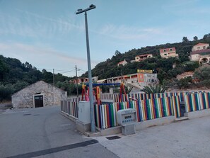 A coastal area with a stone building labeled "PRODROJE," a colorful fence, and a "GRILL-PIZZERIA" sign. - Apartment Dominik - Two Bedroom Apartment with Terrace and Sea View (Smokvica)