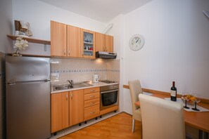 Enjoy cooking in this well-equipped kitchen with an oven, stainless steel refrigerator, and sink.