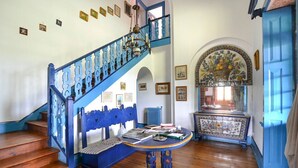 A staircase with blue railings, a wooden floor, a bench, and a table with books and a vase. - Casa Benedita - Six Bedroom Villa, Sleeps 12 (Abade de Neiva)