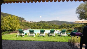 A poolside area with lounge chairs and a pergola.