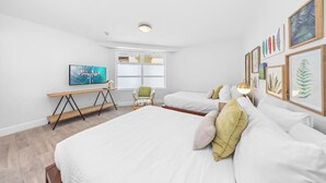 Een slaapkamer met een groot bed, een bureau, een stoel en een raam.