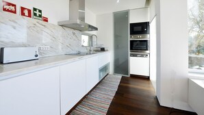 A modern kitchen with white cabinets, a marble backsplash, and stainless steel appliances. - Caminha Views - Two Bedroom Villa, Sleeps 4 (Moledo)
