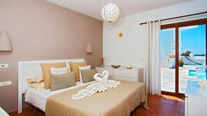 Ein Hotelzimmer mit Bett, Nachttisch, Lampe, Blick auf den Pool und einem Balkon.