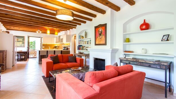 Un salón espacioso con chimenea, una zona de comedor y una cocina al fondo.