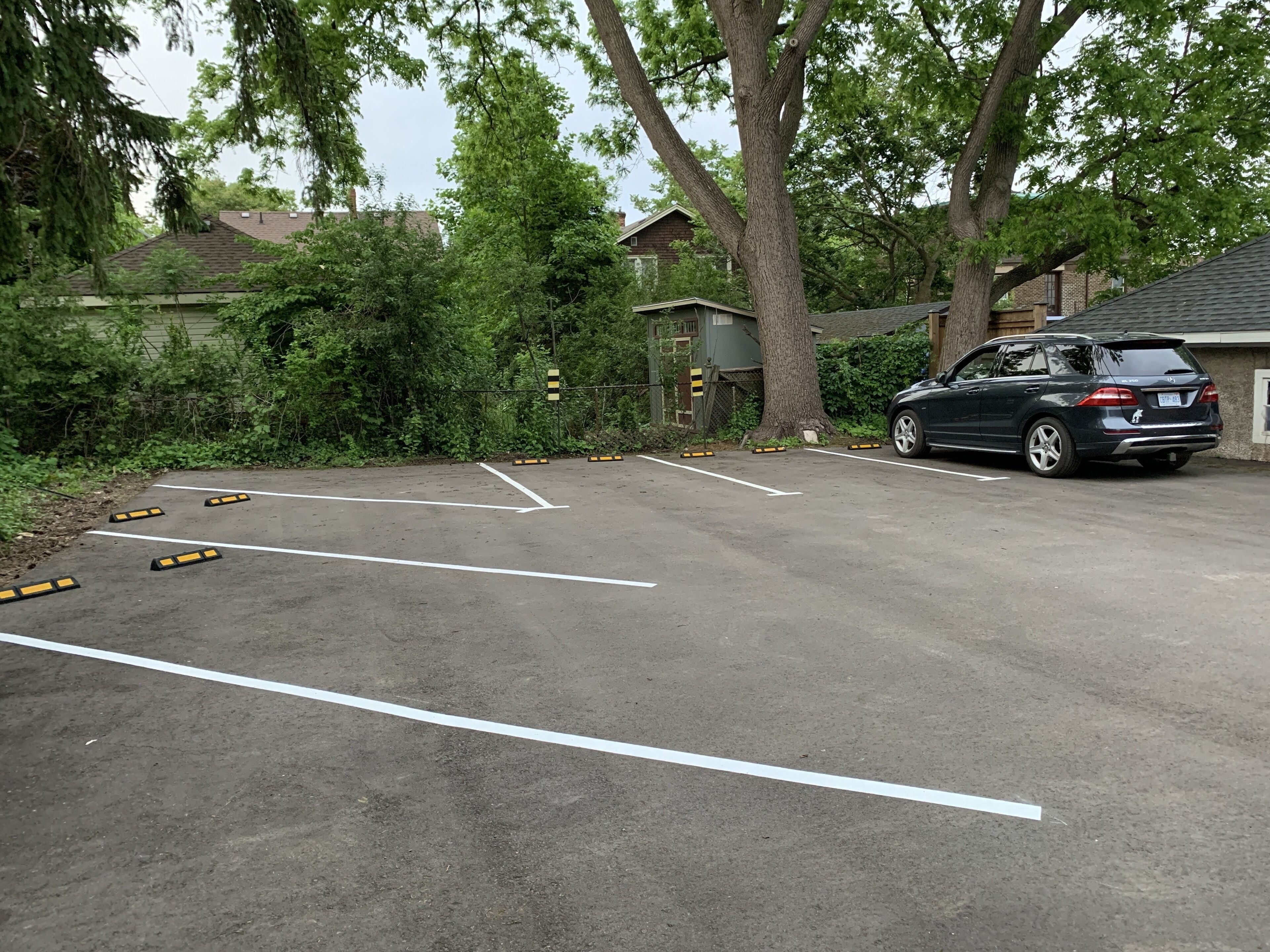 Un estacionamiento con espacios delimitados y un coche estacionado.