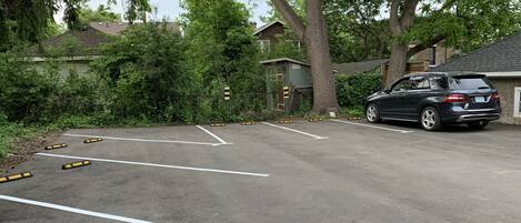 Un estacionamiento con espacios delimitados y un coche estacionado.