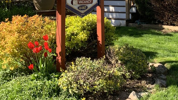 A sign for Ambiance Bed & Breakfast with amenities like private bathrooms, smoke-free, full breakfast, and a contact number. - Ambiance by the Falls Cozy Suite (Niagara Falls)