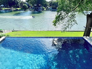 Ein Schwimmbad mit Blick auf einen See und angestellte Boote.