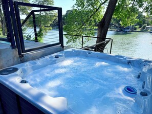 Ein Whirlpool mit Metallrahmen und Blick auf einen See mit Booten.