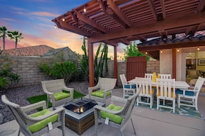 Your backyard oasis features a dining table and firepit.