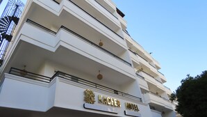 Un hotel de varios pisos con un letrero llamativo que dice "KLEER HOTEL".