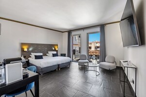 Una habitación de hotel moderna con una cama, un escritorio con ordenador, una silla y una televisión.