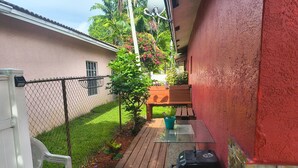 Eine Terrasse mit Grill, Stuhl und Tisch.