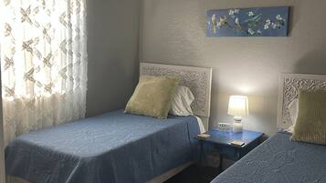 2 dormitorios, tabla de planchar con plancha, cuna de viaje