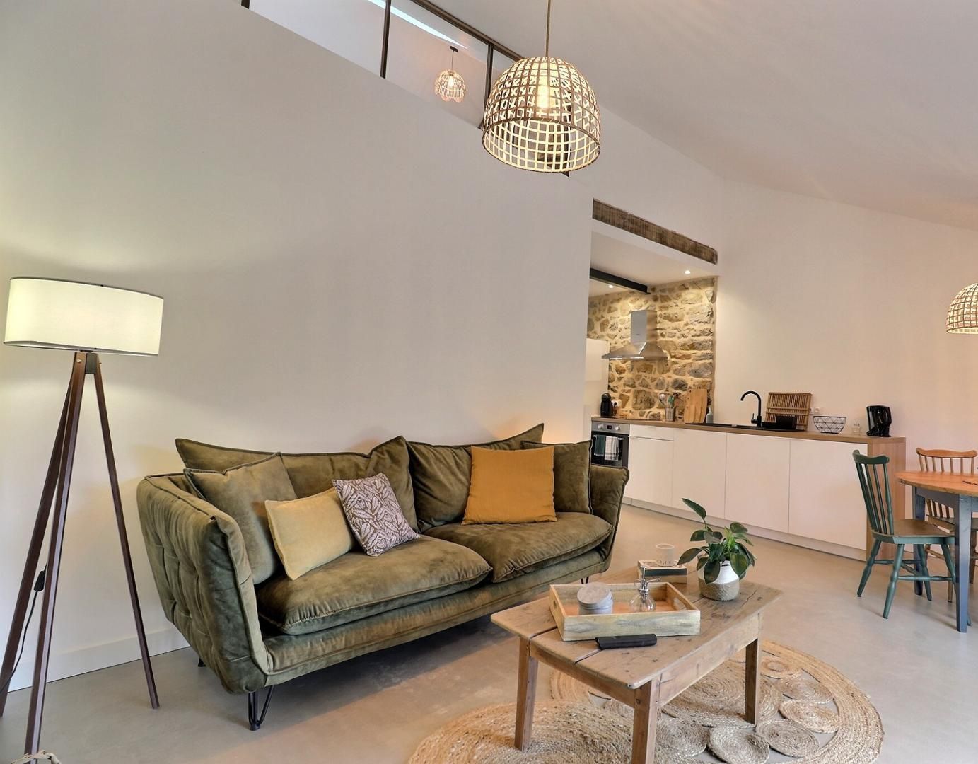 A modern living room with a sofa, coffee table, and dining area with chairs and a table.