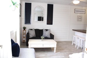 Relax in a cozy room with a comfortable sofa, coffee table, and potted plants.