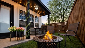 A patio with a fire pit, outdoor seating, and a wooden fence. - Overnight Gallery • The Art House • Near Downtown Dallas • Maduro Collection (Dallas)