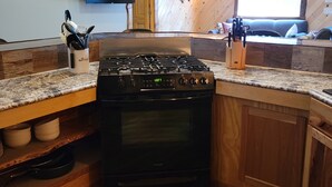 Una cucina con un fornello, mobili impiallacciati in legno e una finestra.