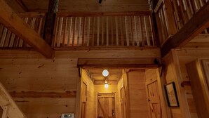 Un intérieur en bois avec un escalier, un ventilateur de plafond et un luminaire.