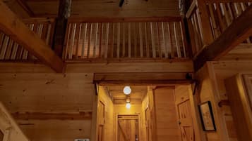 Un intérieur en bois avec un escalier, un ventilateur de plafond et un luminaire.