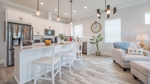 A modern kitchen with white cabinets, stainless steel appliances, and pendant lighting. - 🌴Luxury 4BR Beach Home🏖GULF VIEW🌊4 min Walk To The Beach (Panama City Beach)
