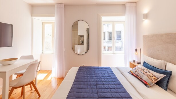 Una habitación de hotel moderna con una cama grande, un escritorio y una silla.