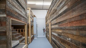 A narrow hallway with wooden panel walls and a staircase on the left.