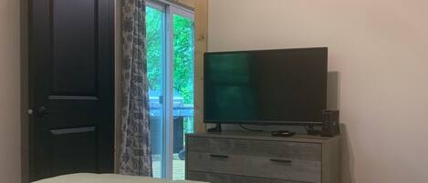 Ein Schlafzimmer mit einem Bett, einem Schminktisch und einem Fernseher.