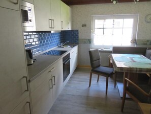 Een keuken met een inbouwoven, een spoelbak en een raam.