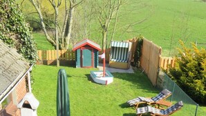 A patio with a table and chairs, a barbecue grill, and a small shed.
