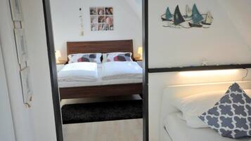 Een slaapkamer met een bed, nachtkastje, wandplank en decoratieve wandversiering.