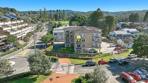 A residential building with a central courtyard, multiple balconies, and a parking area. - Seaview 7 - Prime Position Beachside Holiday (AVOCA BEACH)