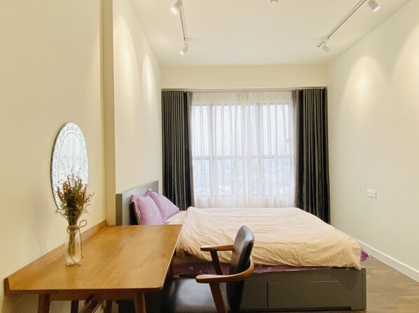A modern bedroom with a bed, a desk, and a chair.