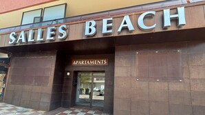 Een gebouw met een bord waarop 'Salles Beach Apartments' staat.