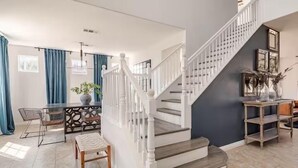 A modern interior with a staircase, dining area, and a living space. - Beautiful 5 BR house with Olympic size Pool and SPA in Indio (Indio)