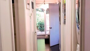 A hallway with a tiled floor, white walls, and a ceiling light. There are doors on both sides, and a window at the end of the hallway. - Old Farm Land by Willamette River Oak Trees Bike Path Shopping Restaurants (Eugene)