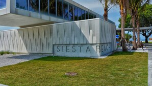 Moderni rakennus, jonka julkisivu on betonia ja jonka alaosassa on kaiverrettuna nimi ”SIESTA BEACH”.