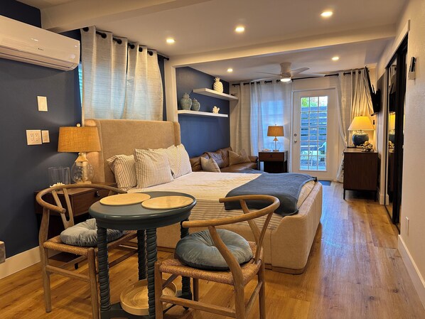 A modern bedroom with a bed, bedside tables, a chair, and a small table. - SIESTA KEY, BLUE ROMANTIC DREAM! 100 FEET TO THE BEACH! (Siesta Key)