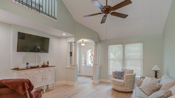 A spacious living room with a ceiling fan, a television mounted on the wall, and a large window with blinds. - 15% off 5 nights or more (Ocean Pines)