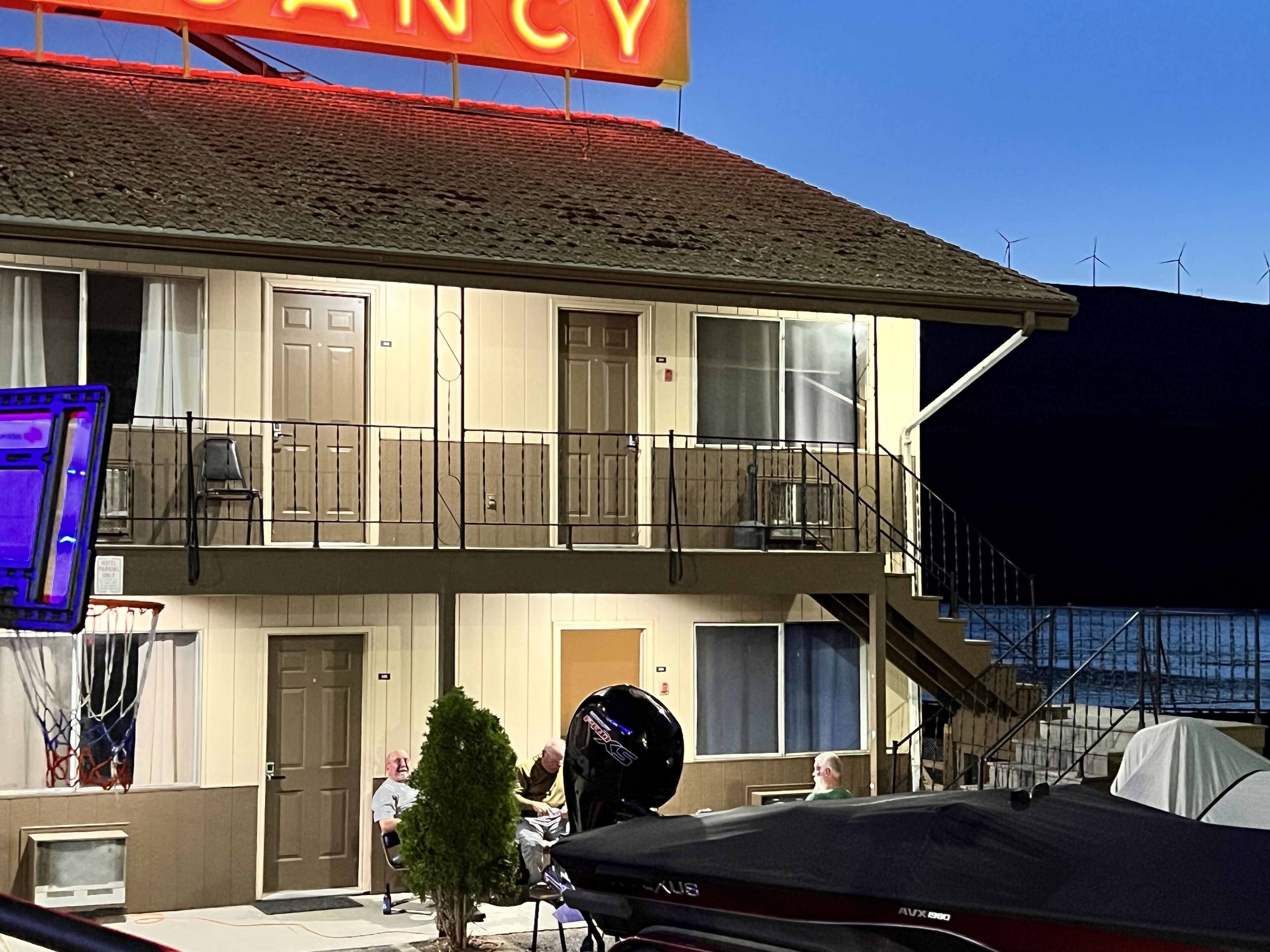 A motel with a two-story structure, a balcony on the second floor, and a sign that reads "MANCY".
