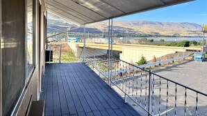 A balcony with a view of a river, mountains, and wind turbines. - BIGGS NU-VU MOTEL (Biggs Junction)